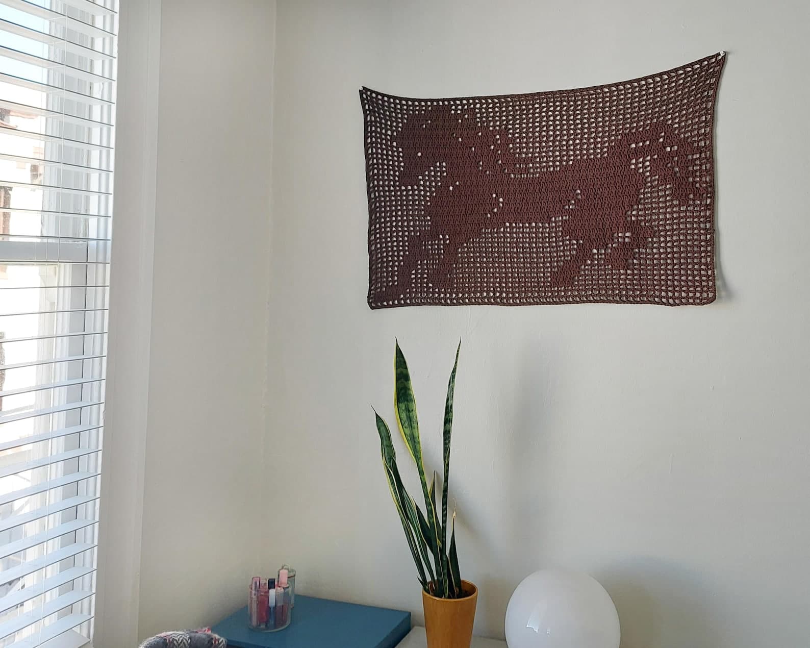 horse filet crochet tapestry hanging on a wall
